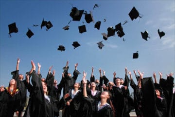 students droping graduation hats